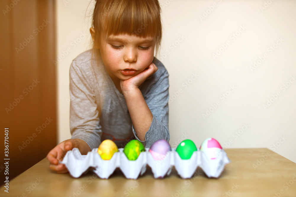 toddler girl looking at a paper tray with self decorated easter eggs toddler girl looking at a paper tray with self decorated easter eggs