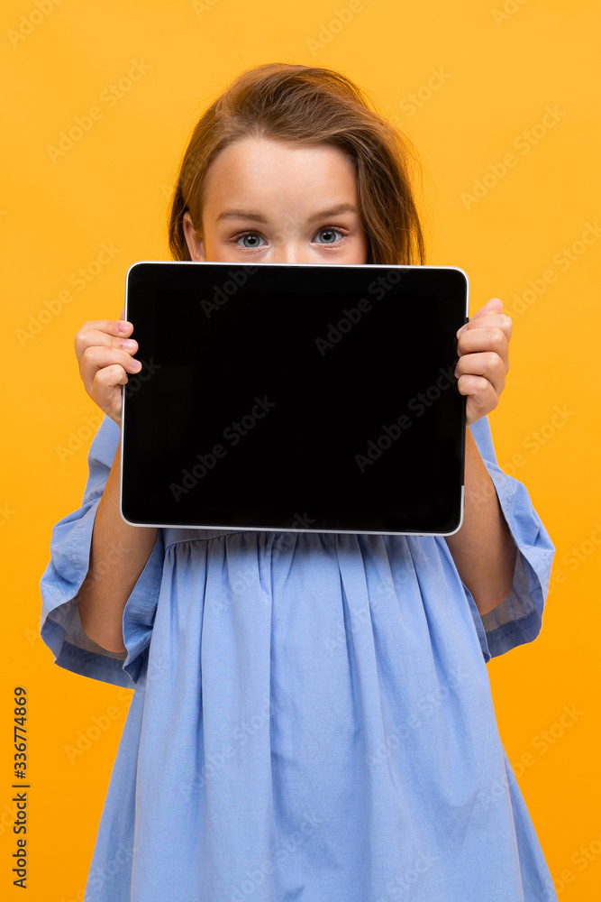 teenager girl in a blue dress with a tablet with a screen mockup teenager girl in a blue dress with a tablet with a screen mockup