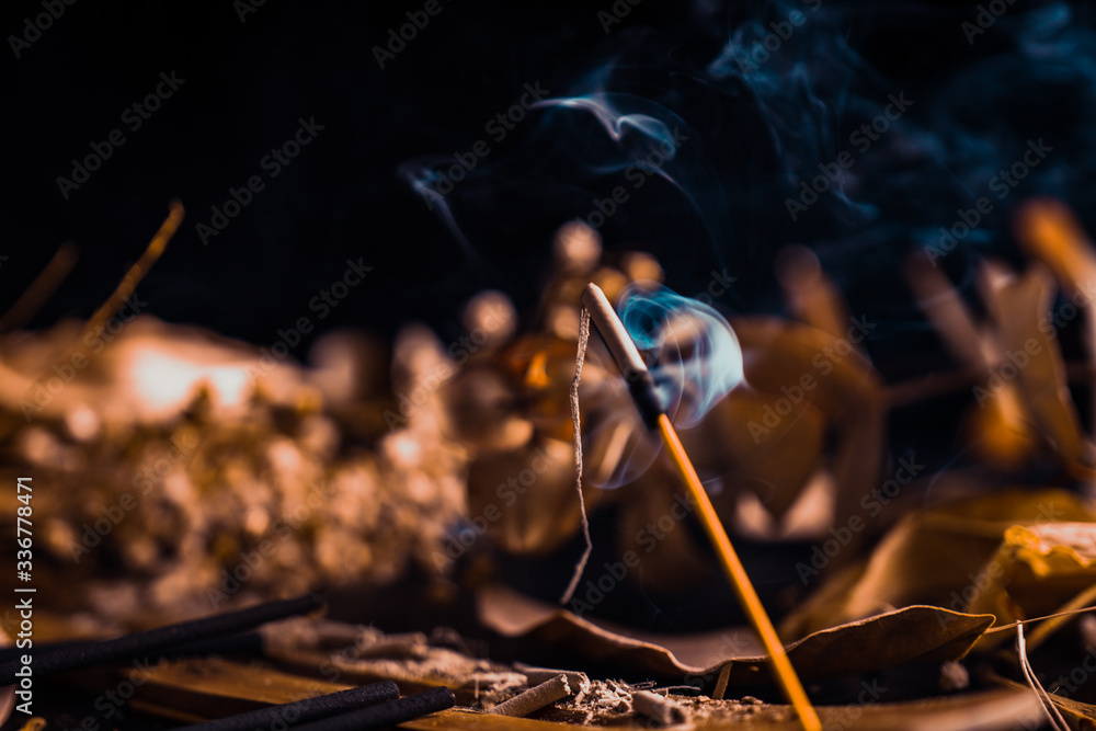 Stick holder and incense stick with leaves and flowers on black background Stick holder and incense stick with leaves and flowers on black background