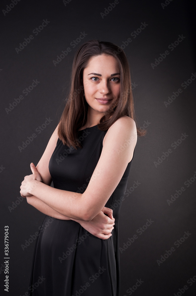 Amazing young lady is posing in the darkness. Elegant black dress, so dark everywhere. Amazing girl with attractive appearance