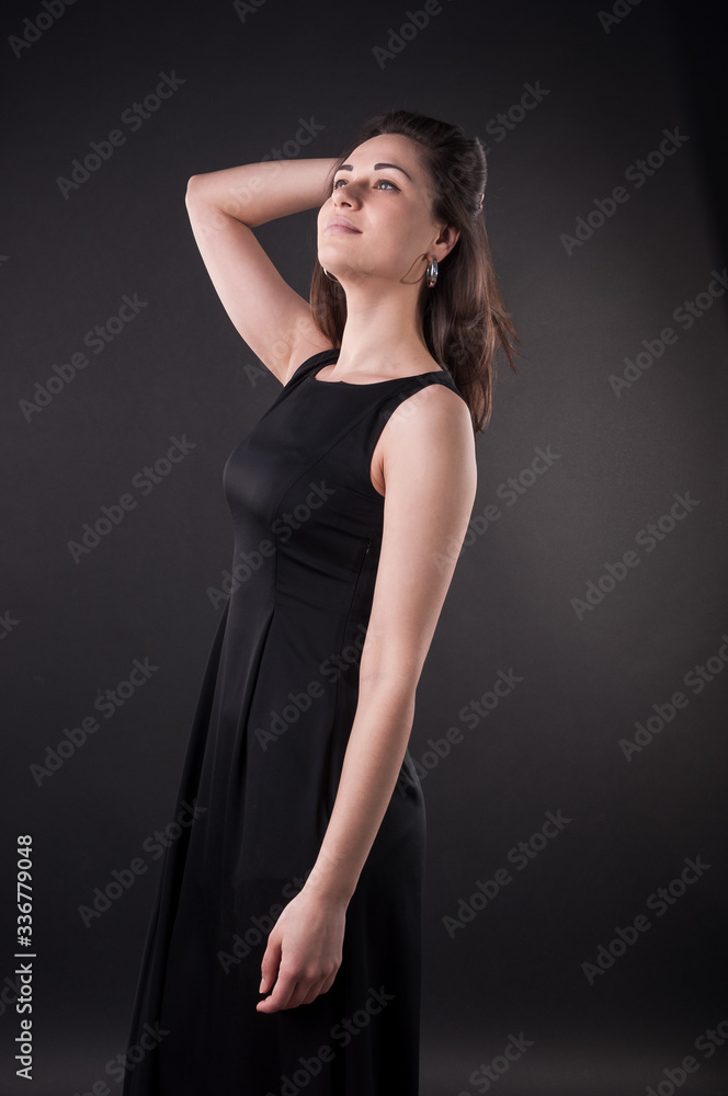 Nice young girl is touching her hair in the dark and looking up