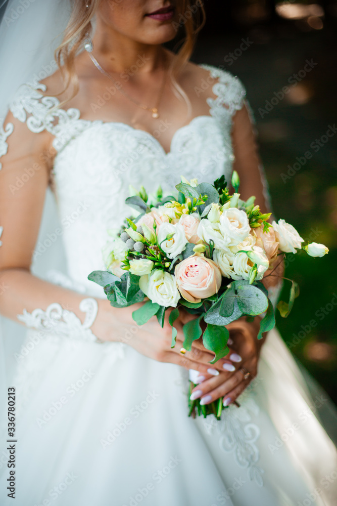 Naklejka premium Bride holds a wedding bouquet, wedding dress, wedding details