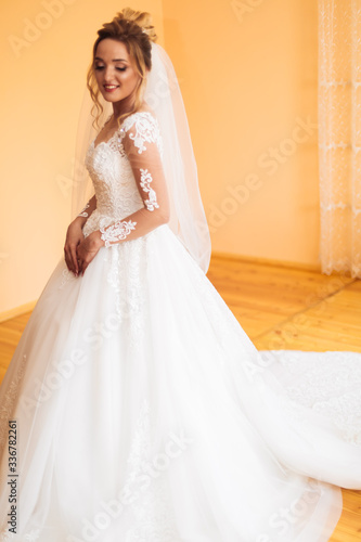 bride in white dress posing while preparing for the wedding ceremony