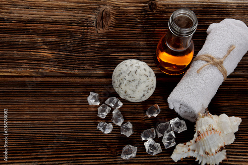 effervescent lavender bath ball, argan oil for the body and clean towels with empty space for text