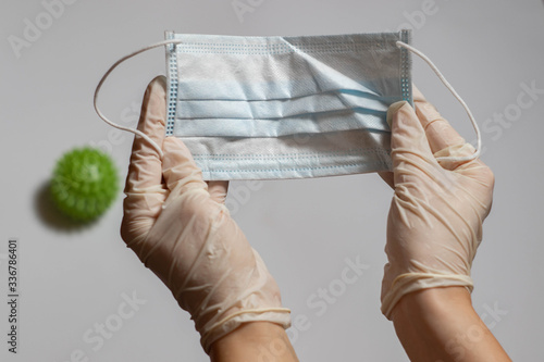 Medical mask in female hands in medical gloves.