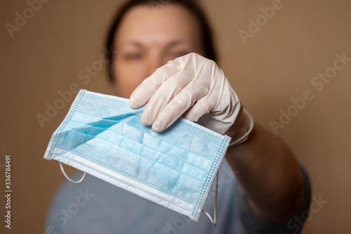 Medical mask in a woman's hand. Close up