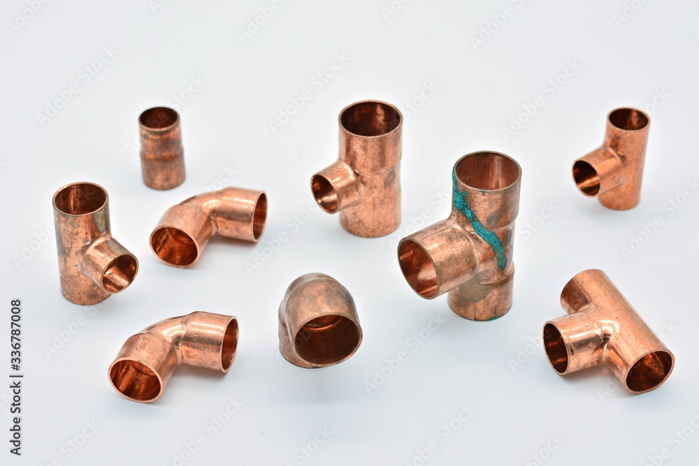Piezas de cobre para agua, destacando una te con óxido de cobre Piezas de cobre para agua, destacando una te con óxido de cobre