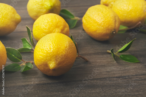 Ripe Fresh lemons on wooden table. Close up.