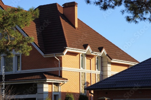 part of a large private house with windows under a brown tiled roof 