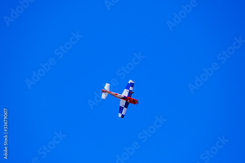 airplane model performs aerobatics in the sky, plane model against blue sky