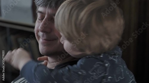 A small child hugs his father.  a little boy shows love for the folder. 