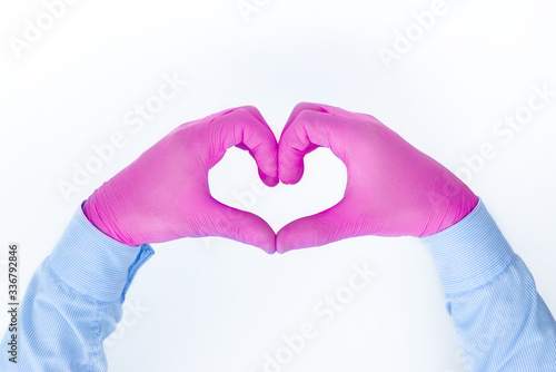 Hands of a caring doctor in medical gloves on a white background show a heart with their fingers  a professional takes care of our health  a medical concept  a place for text