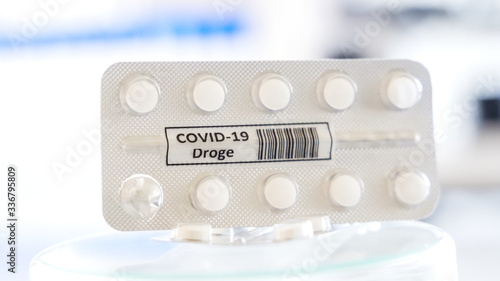 Closer look of the white tablet with drug Covid-19 Droge written in German sign for coronavirus photo