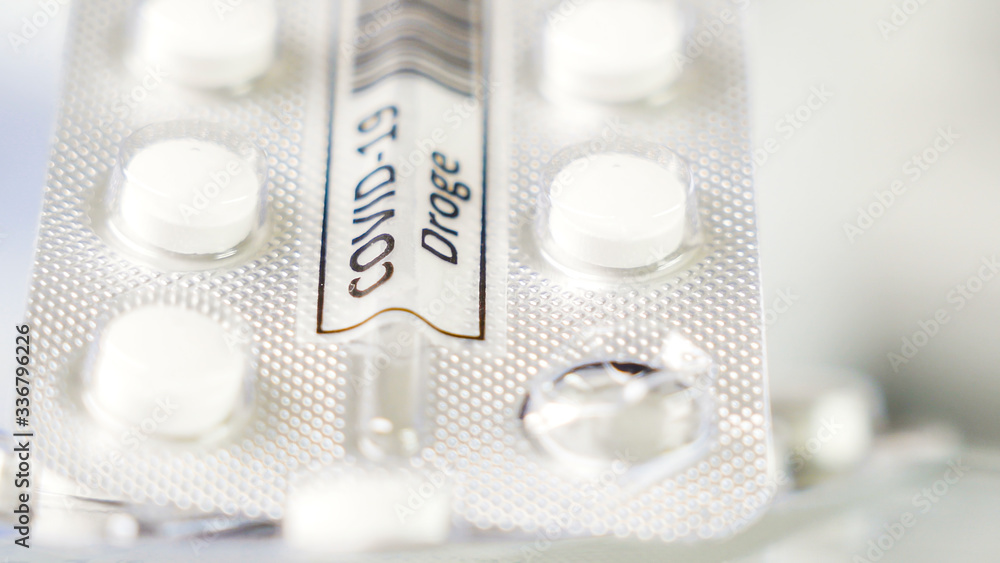 White small tablets for coronavirus with drug Covid-19 Droge written in German sign on it White small tablets for coronavirus with drug Covid-19 Droge written in German sign on it