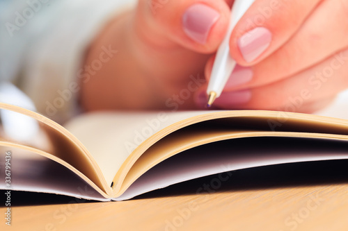 female hands write in a notebook . Office place . Close up view - Image