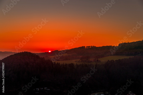 Wallpaper Mural Close up sunset timelapse when sun is behind hills and mountains full of trees and moving clouds behind which sun sets a strong yellow-orange color view of the surrounding nature Beskydy Mountains Torontodigital.ca