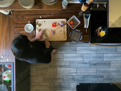 overhead view of woman cooking in real messy kitchen
