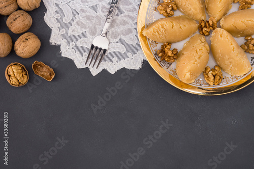 Turkish famous traditional homemade flour halva served with walnut in plate on rustic background  turkish dessert for holy night or funeral