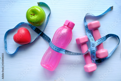 high angle view of water bottle, apple and dumbbell on table