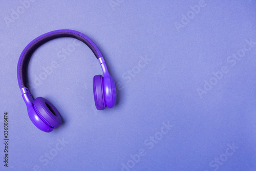 Purple headphones on purple background, top view. Copy space. Space for text. 
