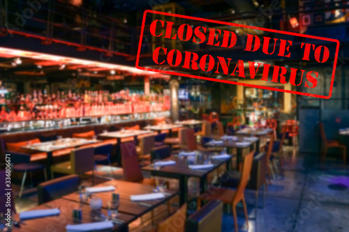 Defocused, blurred view of interior of an upmarket bar or restaurant, empty and closed due to coronavirus or covid 19 pandemics