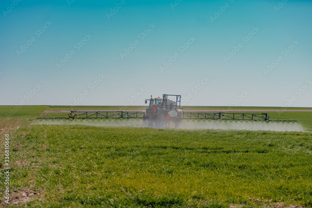 Naklejka premium Tractor Spraying Herbicides on Field Agriculture