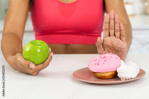 Fit Afro Girl Holding Apple And Rejecting Sweets