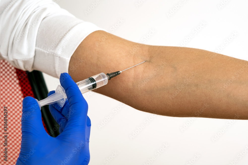 Close up of doctor hand in blue protective glove making injection with syringe to a patient. Close up of doctor hand in blue protective glove making injection with syringe to a patient.
