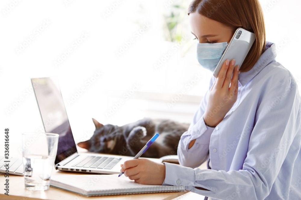 Woman employee in mask with laptop computer in self isolation working from home, coronavirus covid-19 quarantine. Remote working of business worker, online education. Prevention of virus spread Woman employee in mask with laptop computer in self isolation working from home, coronavirus covid-19 quarantine. Remote working of business worker, online education. Prevention of virus spread
