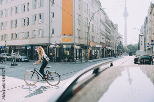 Full length of female executive riding bicycle on street in city photo