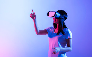 Girl in virtual reality glasses looks up