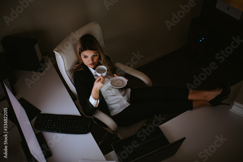 Young attractive caucasian businesswoman drinking coffee in office. Break from work