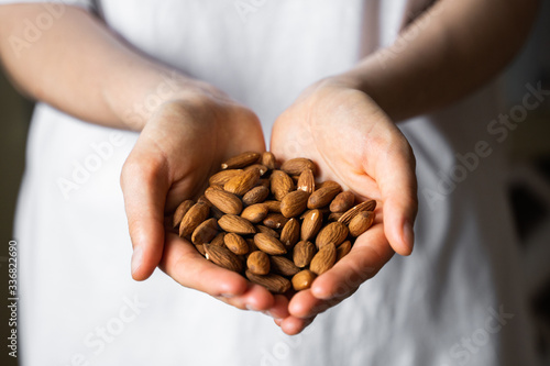 Almond in a womans hands. Almonds nuts is a healthy vegetarian protein and nutritious food. Nuts in a humans hand.