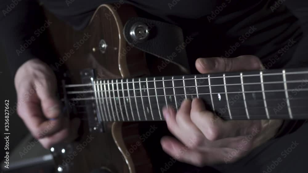 man's hands playing solo on a brown electric guitar man's hands playing solo on a brown electric guitar