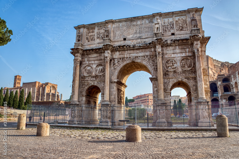 Triumphal Arch of Constantine near Colosseum with Roman Forum in background - Rome, Italy.