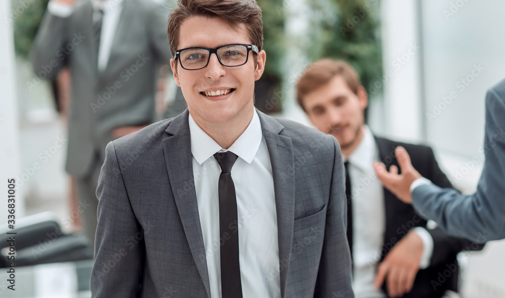 young businessman in glasses on an office background .