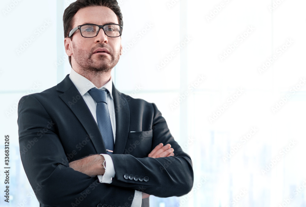 Businessman standing near the window and looking into it Businessman standing near the window and looking into it