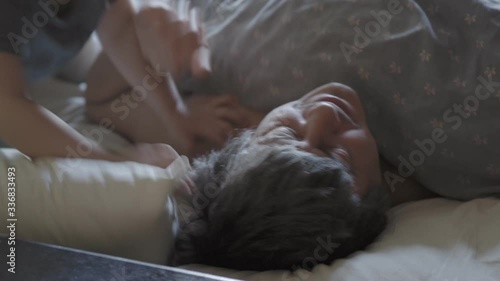 little boy wake up their dad.  Cute toddler son and father sleeping together on bed in bedroom at home.