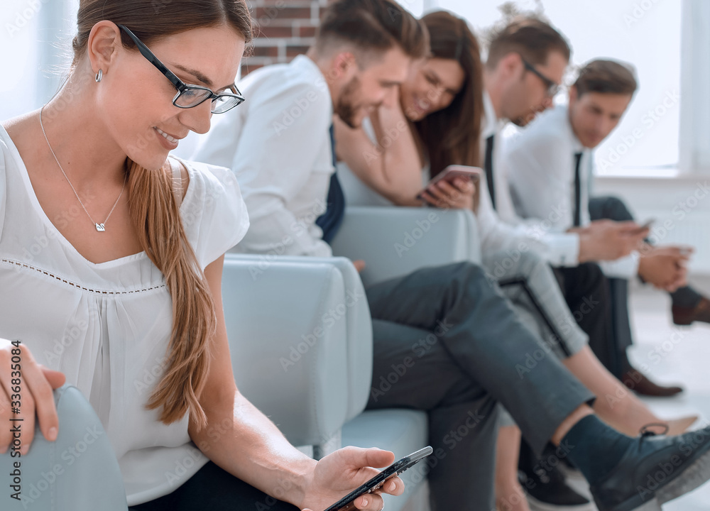 in the foreground.a young business woman is waiting for an interview in the foreground.a young business woman is waiting for an interview