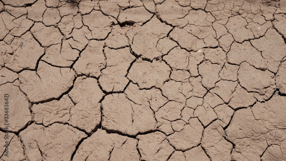 cracked clay texture. beautiful pattern of cracks in a brown clay wall. dried clay. cracked clay texture. beautiful pattern of cracks in a brown clay wall. dried clay.