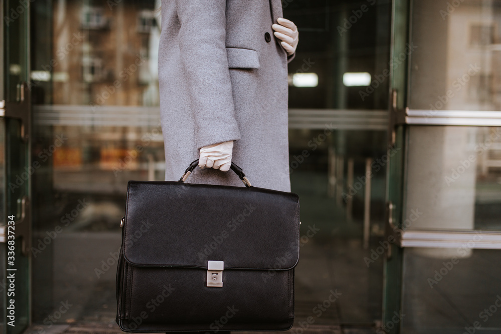 Young attractive caucasian businesswoman with mask and bag in front of company Young attractive caucasian businesswoman with mask and bag in front of company