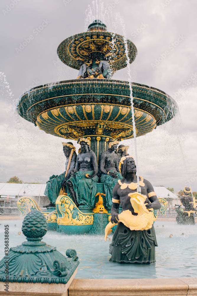 Fountain of River Commerce and Navigation in Place de la Concorde in the center of Paris France, on a summer day, with drops of water falling from the golden fountain