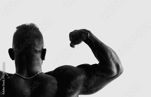 Pumped man on a white background. Sports Hall. Muscle.Healthy lifestyle. Tense muscles. Back and head. Glasses on the man. Black and white picture.