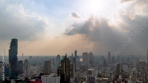 Sunburst or sun rays or god light beam through the cloud over Bangkok business district city center above Silom area; zoom in – Time Lapse