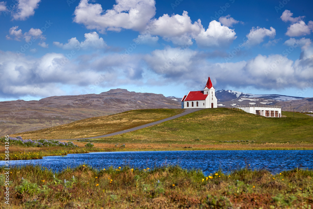 Panoramic view of Ingjaldsholl church in Hellissandur, Iceland. The field of blooming lupine flowers with background of Snaefellsjokull mountain. Beautiful sunny scenery of summer Iceland. Postcard. Panoramic view of Ingjaldsholl church in Hellissandur, Iceland. The field of blooming lupine flowers with background of Snaefellsjokull mountain. Beautiful sunny scenery of summer Iceland. Postcard.
