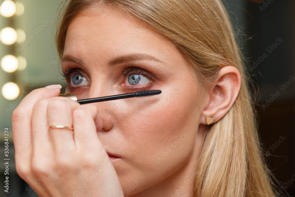 Makeup artist creates voluminous eyelashes of the model. Makeup artist creates voluminous eyelashes of the model.