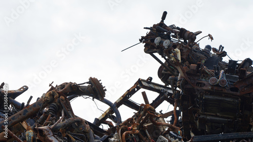 automobile dump of rusty metal. structures and scrap texture. broken parts, rusty wheel springs, texture of mountains of deformed parts and units of vehicles photo