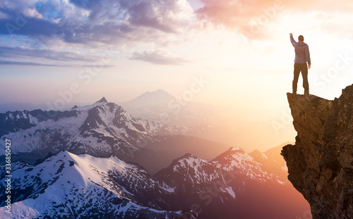 Adventure, Explore and Lifestyle Concept Composite. Adventurous Man Hiker With Hands Up on top of a Steep Rocky Cliff. Sunset or Sunrise. Landscape Taken from Washington, USA. © edb3_16