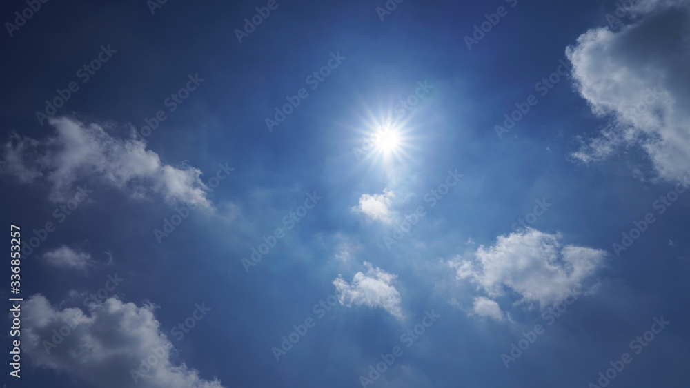 blue sky with white clouds and bright sun. dramatic summer sky background