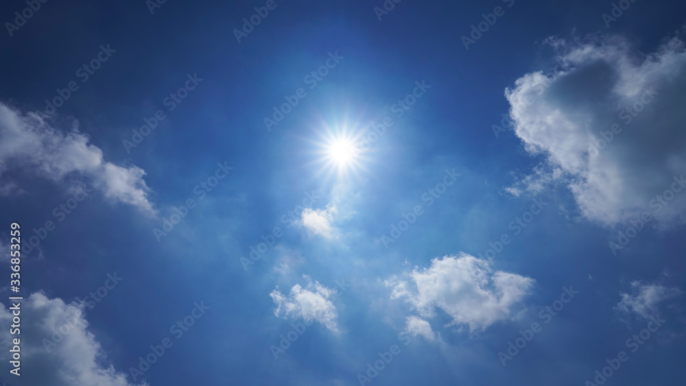 blue sky with white clouds and bright sun. dramatic summer sky background